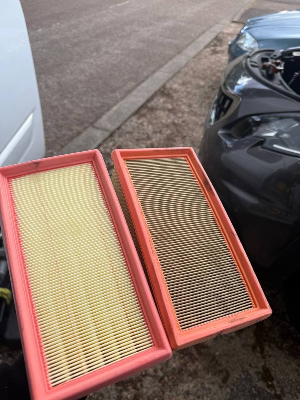A clean air filter beside the dirt filled one it replaced