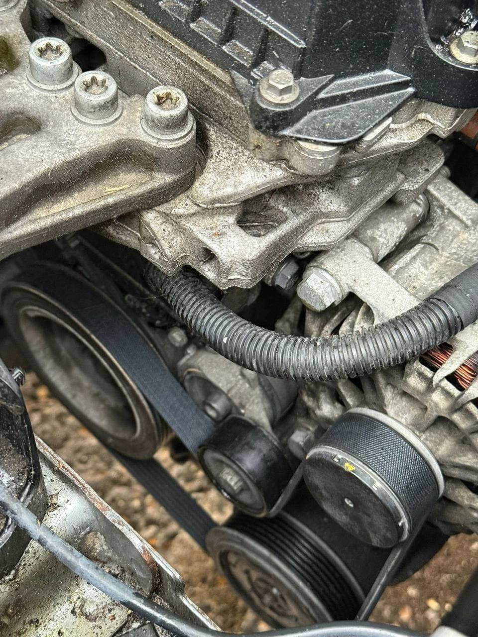 The auxiliary belt, pulleys and alternator on an engine with the covers off