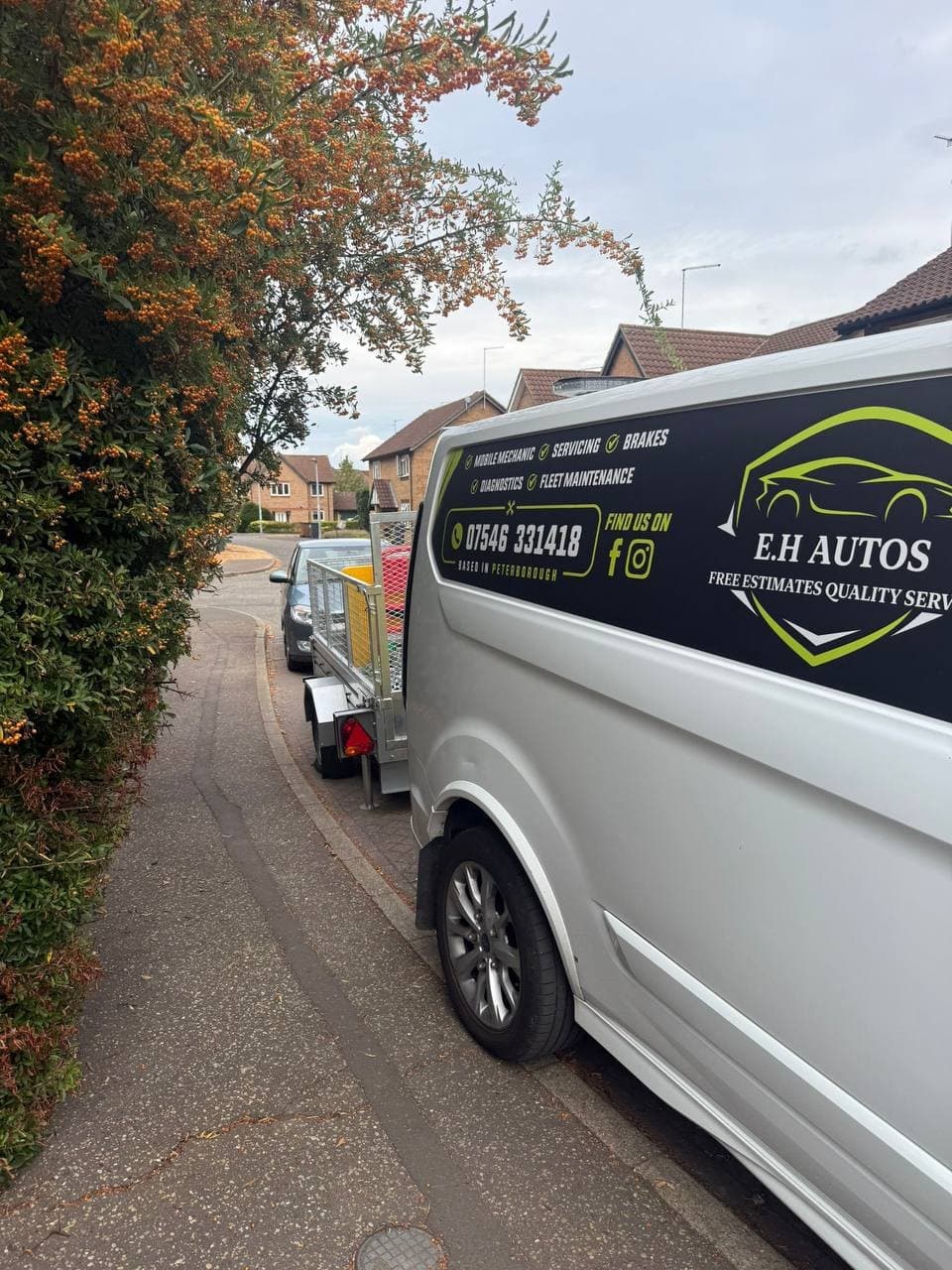 The EH Autos van and trailer parked on a residential street