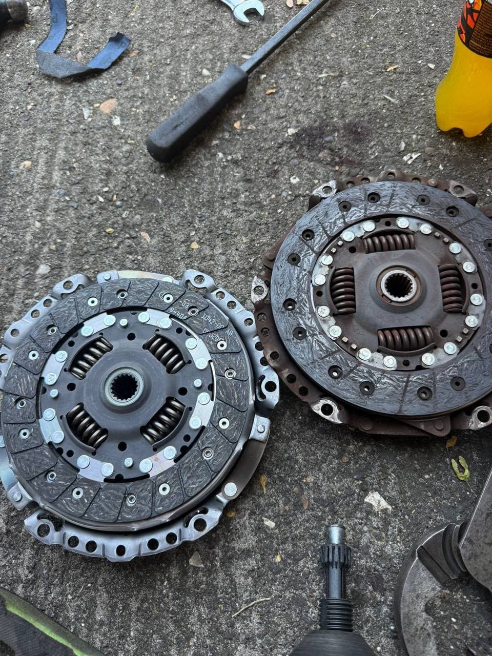 A new clutch kit laid out beside the worn clutch it replaced