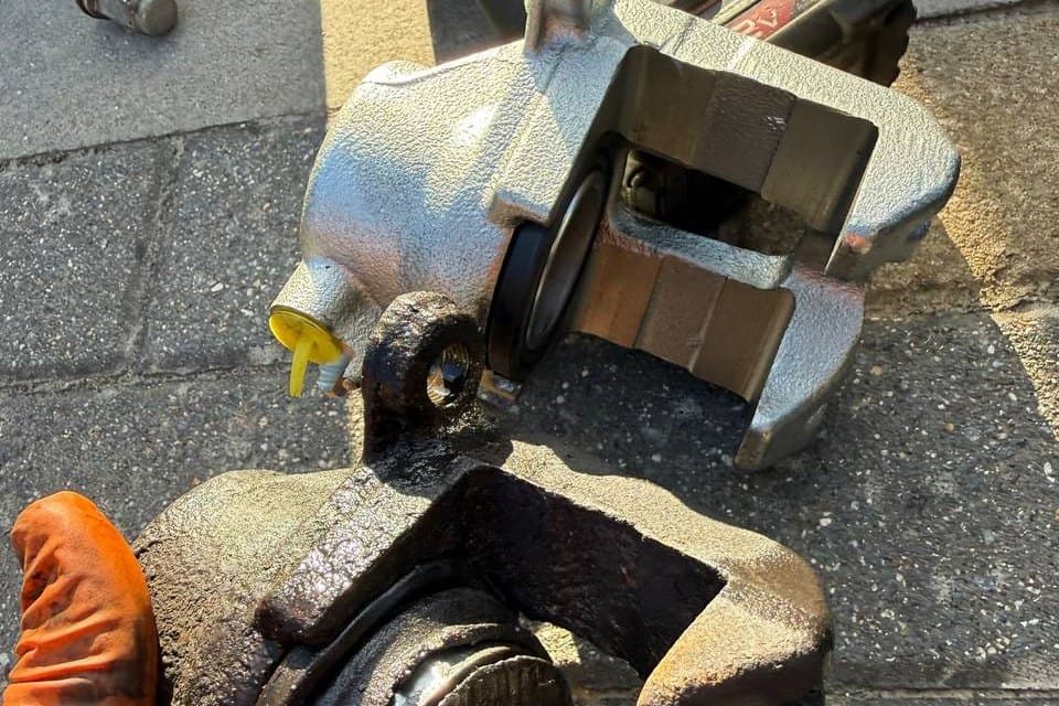 A newly plated brake caliper beside the corroded one taken off the car