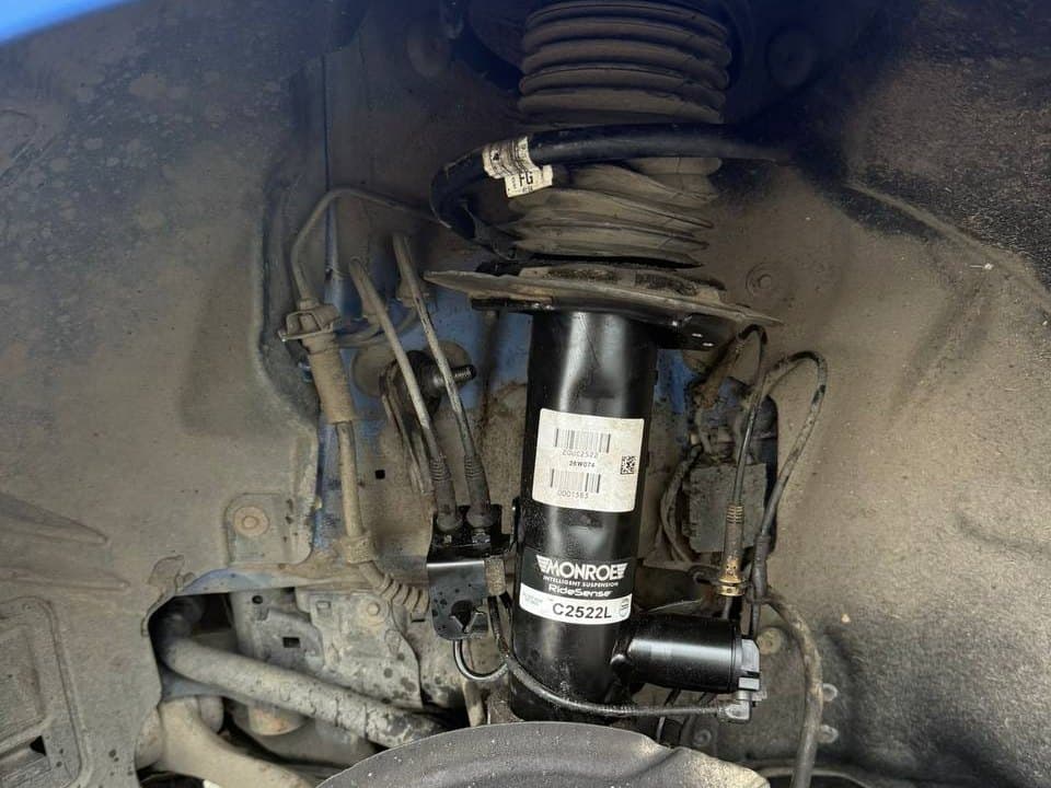 A new Monroe shock absorber fitted to the front suspension of a car
