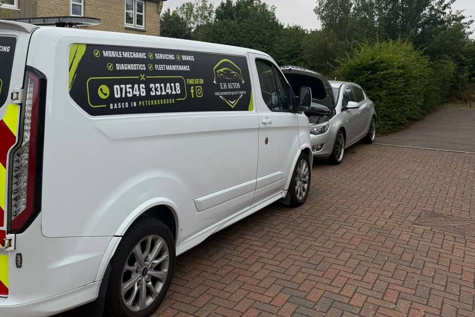 The EH Autos van parked outside a customer's home beside the car being worked on